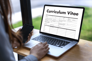 Woman writing her CV on a laptop