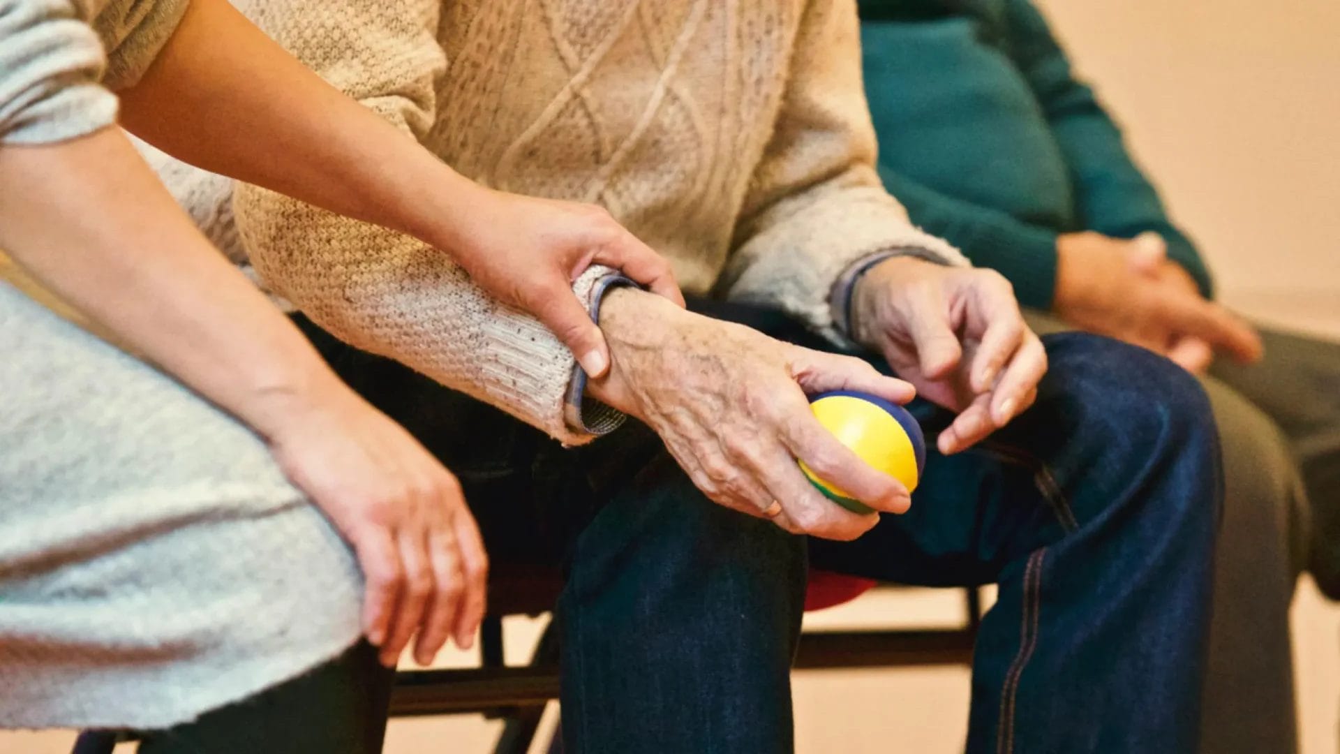 An older person holding a stress ball